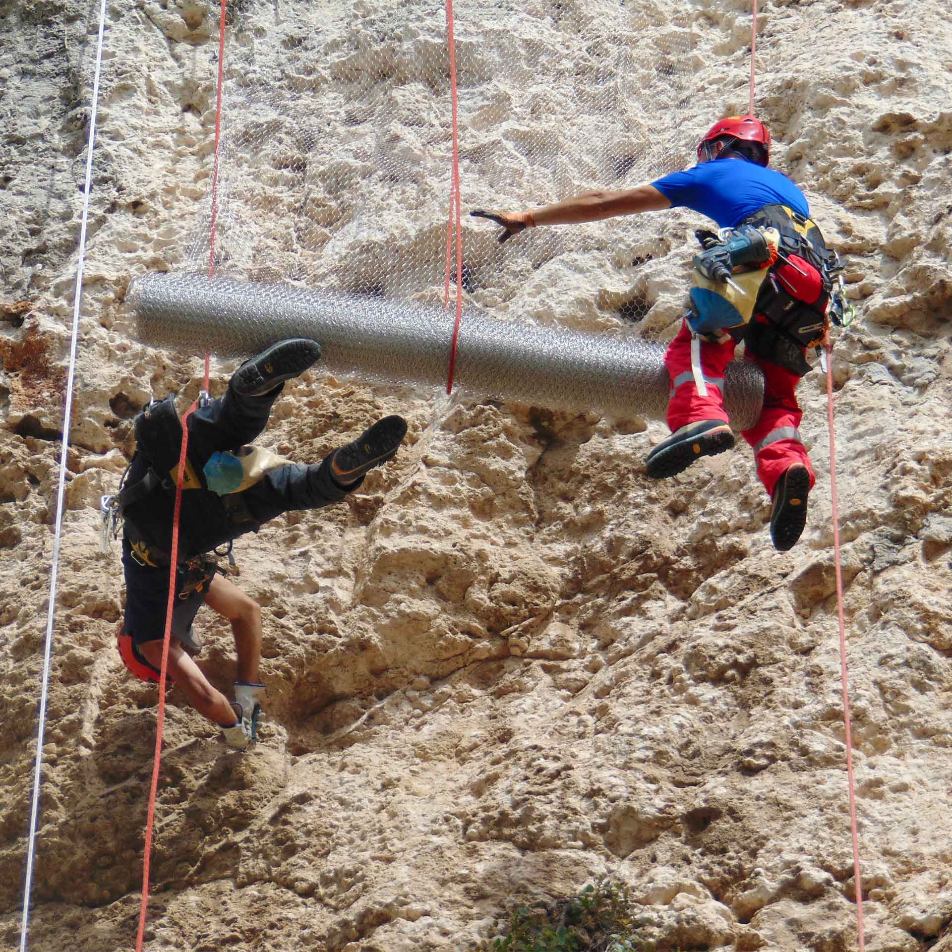 Grotta Cordari e Grotta Salnitro, (SR). Due rocciatori applicano rete di contenimento su parete calcarea assicurati da corde