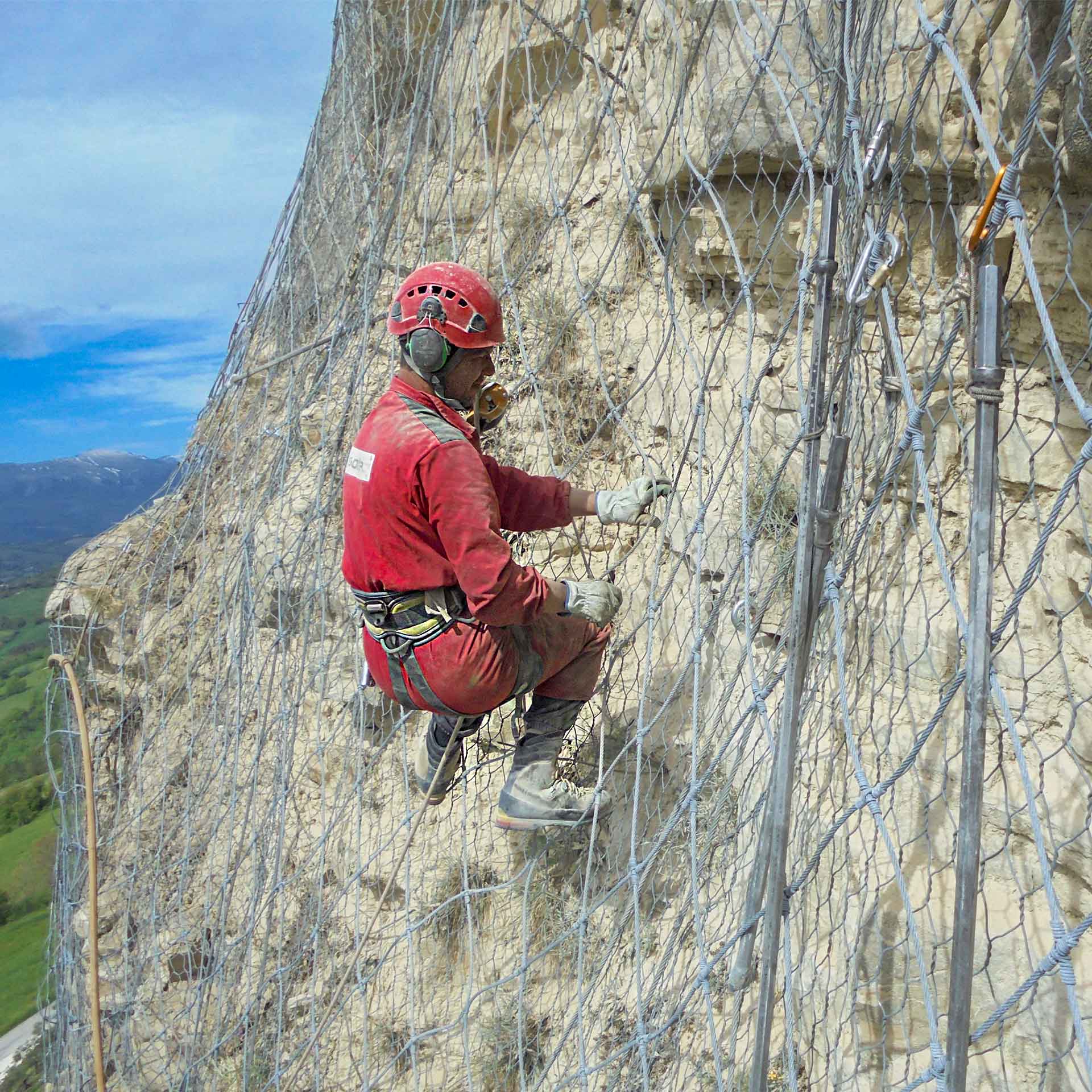 Monte San Martino (MC). Rocciatore assicurato da una corda ispeziona la parete rocciosa